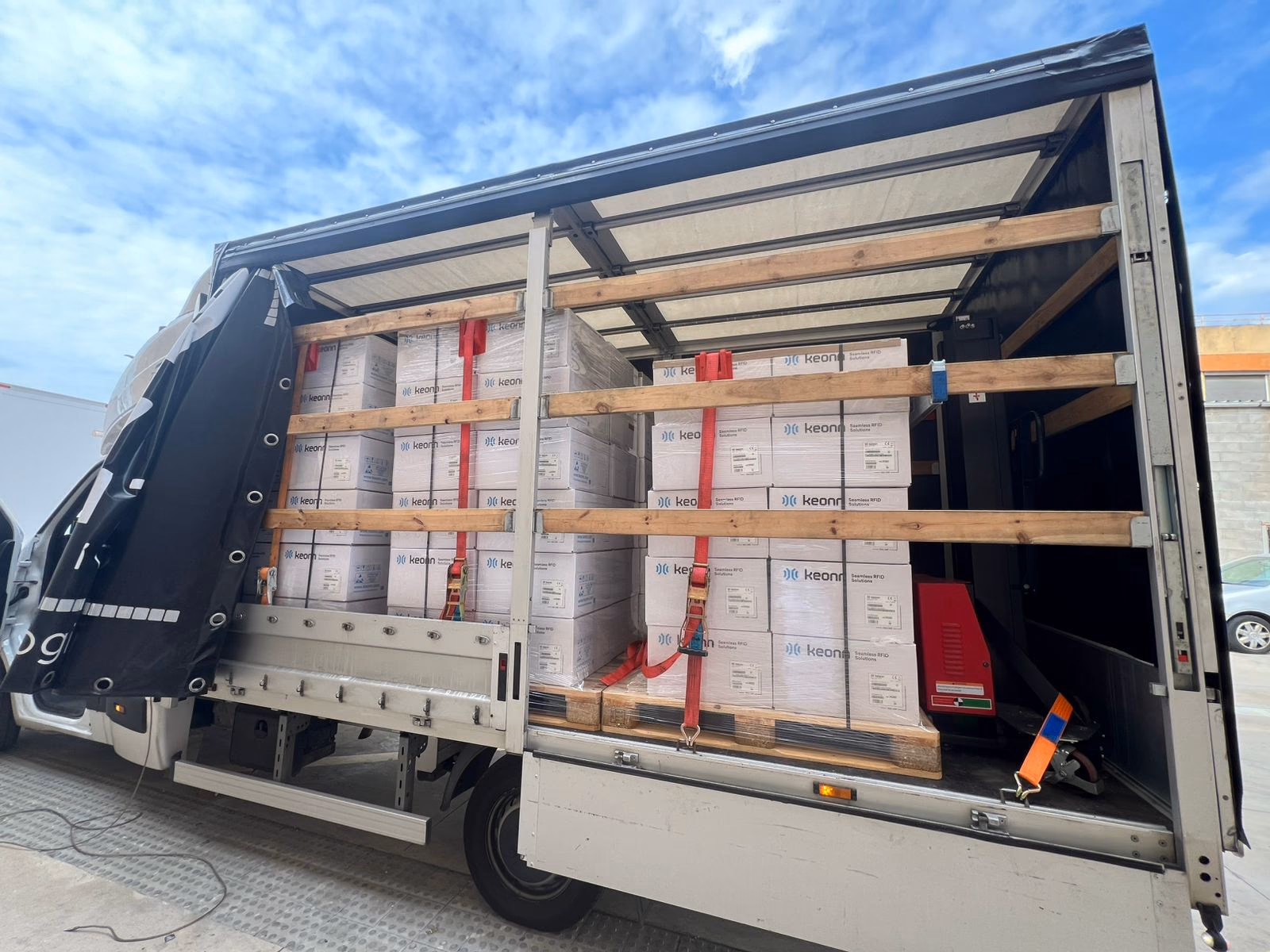Palletised cargo secured with straps inside a curtain-side vehicle